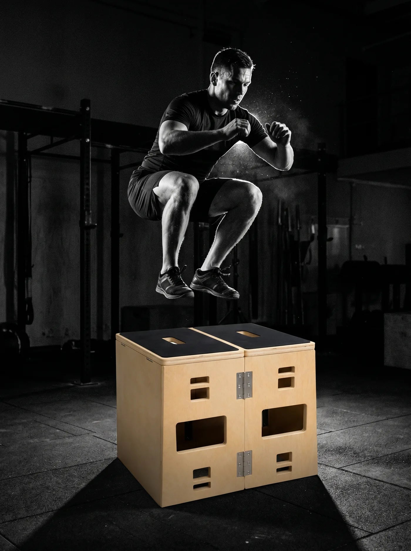 Atleet in de lucht boven de PLYOFOLD in een donkere gym